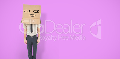 Composite image of businessman standing with box on head