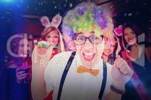 Composite image of geeky hipster wearing a rainbow wig holding p