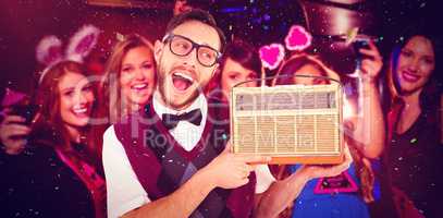 Composite image of geeky hipster holding a retro radio