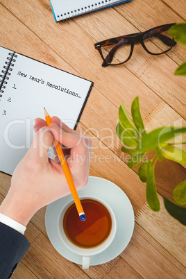 Composite image of hand writing with a pencil