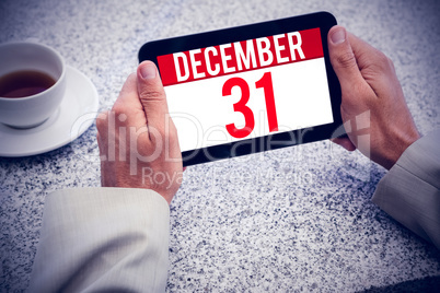 Composite image of businessman holding small tablet at table