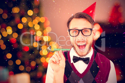 Composite image of geeky hipster in party hat with horn