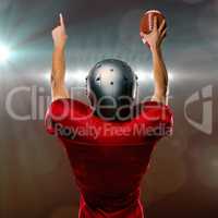 Composite image of rear view of american football player with arms raised