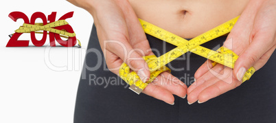 Composite image of close-up mid section of a woman measuring wai