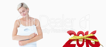 Composite image of happy woman holding scales