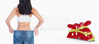 Composite image of back of woman holding her too big jeans