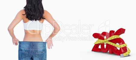 Composite image of back of woman holding her too big jeans
