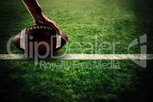 Composite image of american football player holding ball