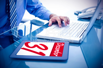 Composite image of businessman using his laptop