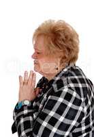 Praying senior woman in profile.