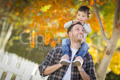 Mixed Race Boy Riding Piggyback on Shoulders of Caucasian Father