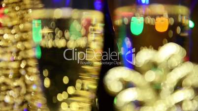 Champagne is poured into glasses on a background of Bengal lights and garlands