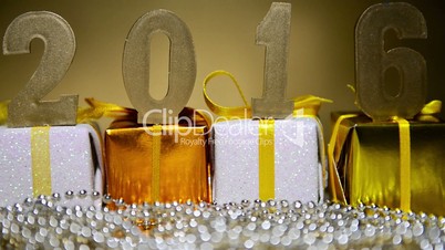 2016 figures are on the Christmas gifts on the background of sparklers. New Year composition