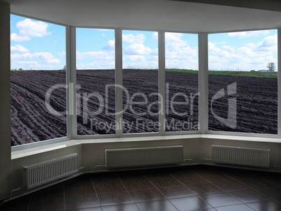 plastic windows overlooking plowed land ready for planting