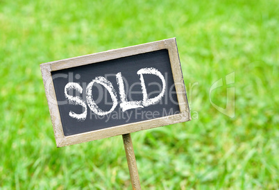 Sold - chalkboard on green grass background