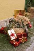 Weihnachtspakete mit Stroh und Tannenzweigen auf einem Schlitten