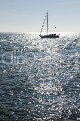 Sailing boat against the sun.