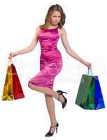Young girl stands on one leg holding shopping bags