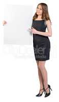 Young girl is holding a big empty billboard, shows forefinger on him