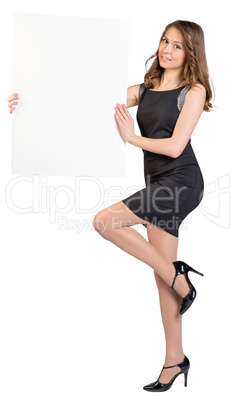 Girl is holding a big empty billboard, standing on one leg