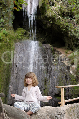 little girl meditates in nature