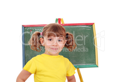 little girl standing in front of a drawing board