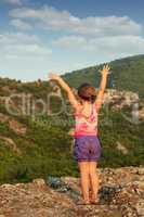 little girl standing on mountain peak