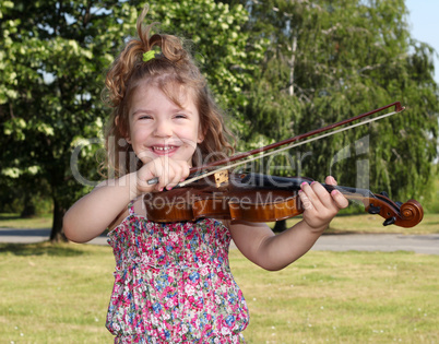 little girl with violin in park
