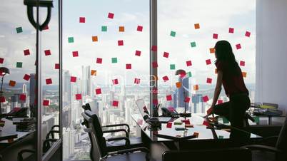 1 Business Person Attaching Sticky Notes On Large Window