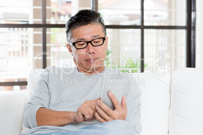 Mature Asian man using smartphone