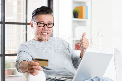 Asian man making online payment and thumb up