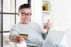 Asian man making online payment and thumb up