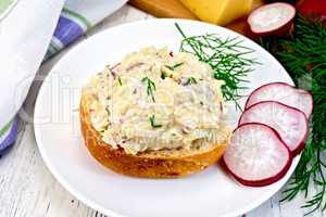 Appetizer of radish and cheese on bun in plate with napkin