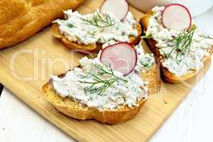 Bread with pate of curd and radish on light board