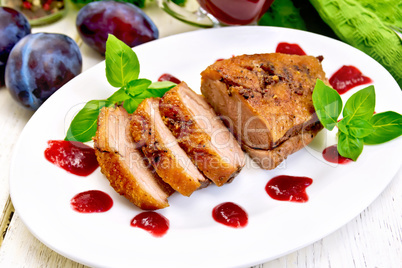 Duck breast with plum sauce and basil on plate
