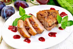 Duck breast with plum sauce and basil on plate