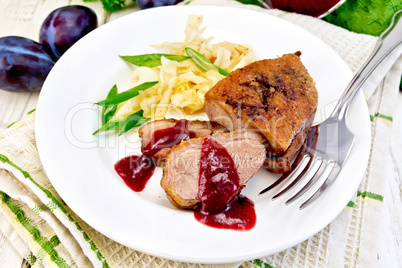 Duck breast with plum sauce and green onions in plate on napkin