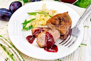 Duck breast with plum sauce and green onions in plate on napkin