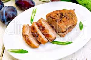 Duck breast with plum sauce and green onions in white plate