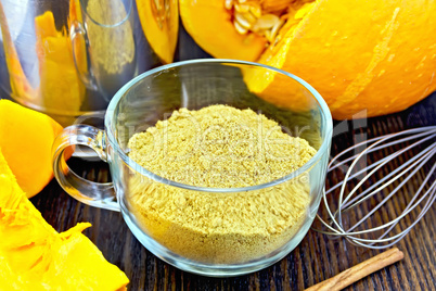 Flour pumpkin in glass cup with mixer on board