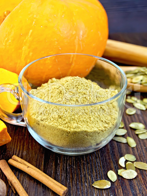 Flour pumpkin in glass cup with seeds on board