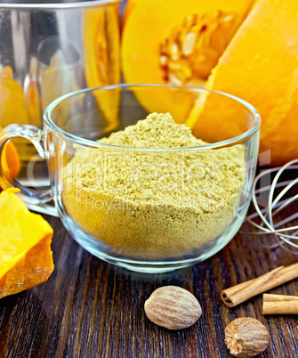 Flour pumpkin in glass cup with sieve and cinnamon on board
