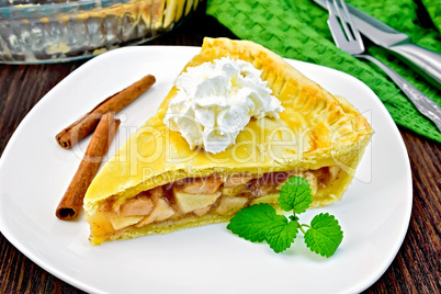 Pie apple with cream and mint in plate on board