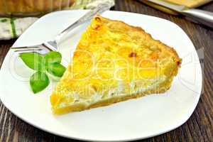 Pie with cheese and leeks in plate on board