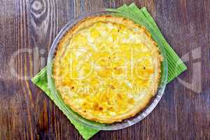 Pie with cheese and leek in glass pan on board