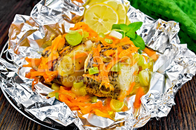 Pike with carrots in foil on board