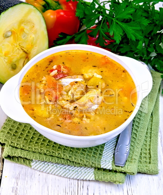 Soup fish with zucchini and peppers on light board