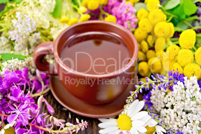 Tea from flowers in clay cup on board