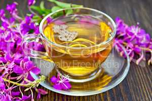 Tea from fireweed in glass cup on dark board