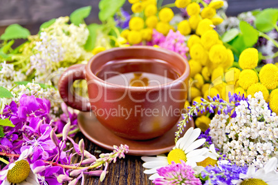 Tea from flowers in clay cup on dark board